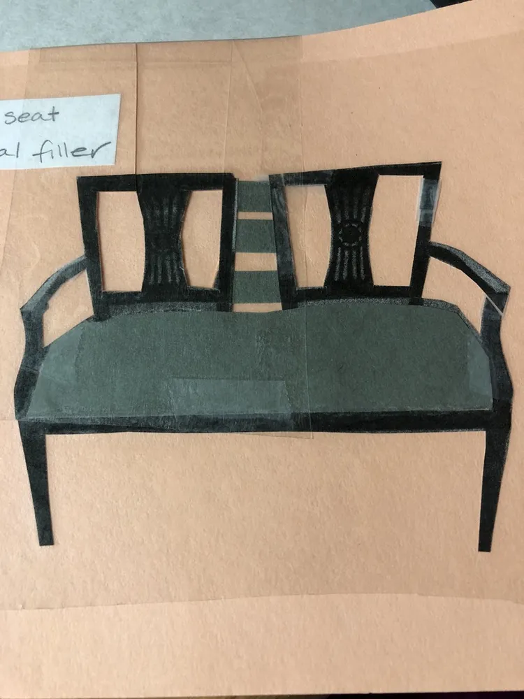Paper-and-tape mockup planning the bench from two chairs