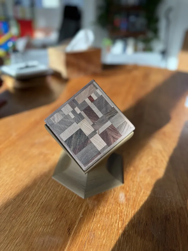 A mosaic coaster set on a green printed stand