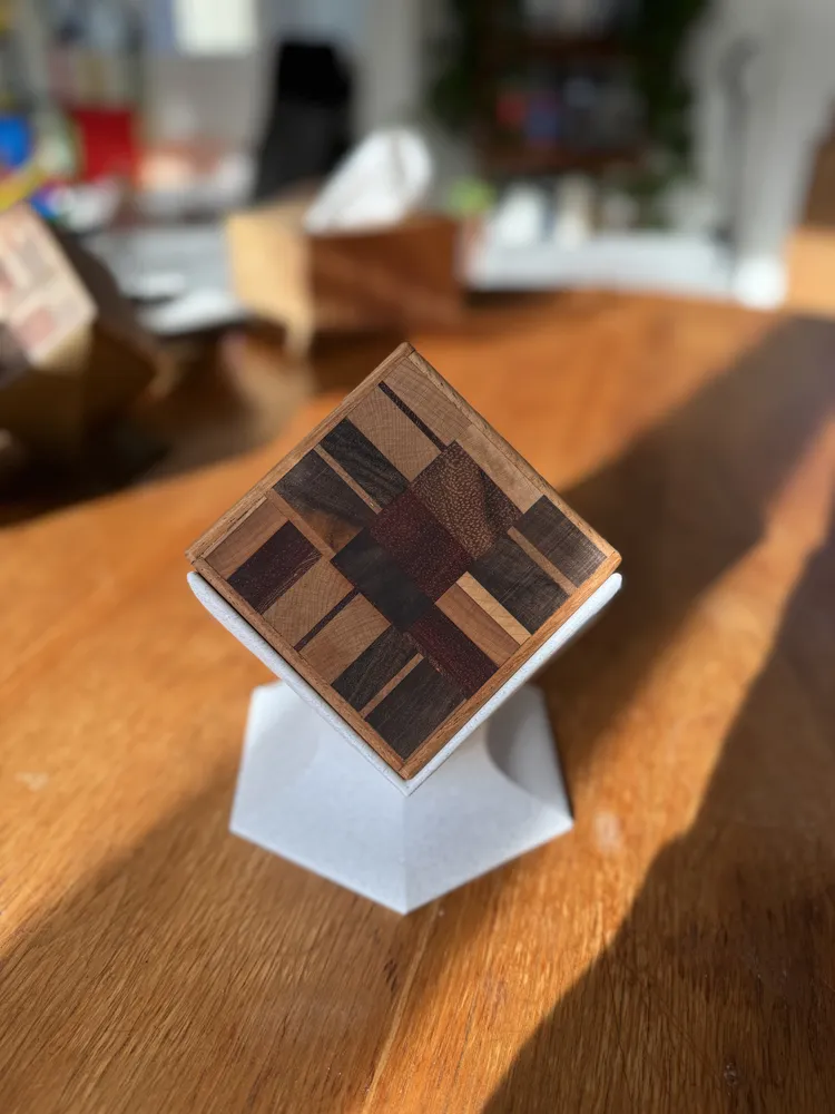 A coaster set with a red and purple mosaic on a white stand