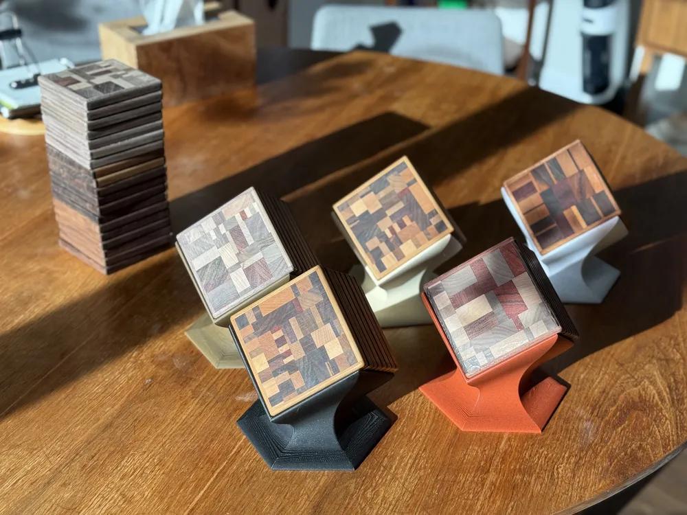 The full batch of coaster sets on color-matched stands, with a stack of spares