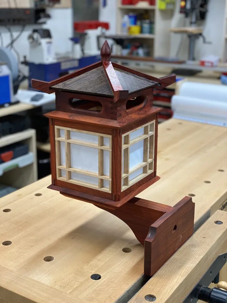 Japanese-style wooden garden lantern with shoji panels and a peaked roof