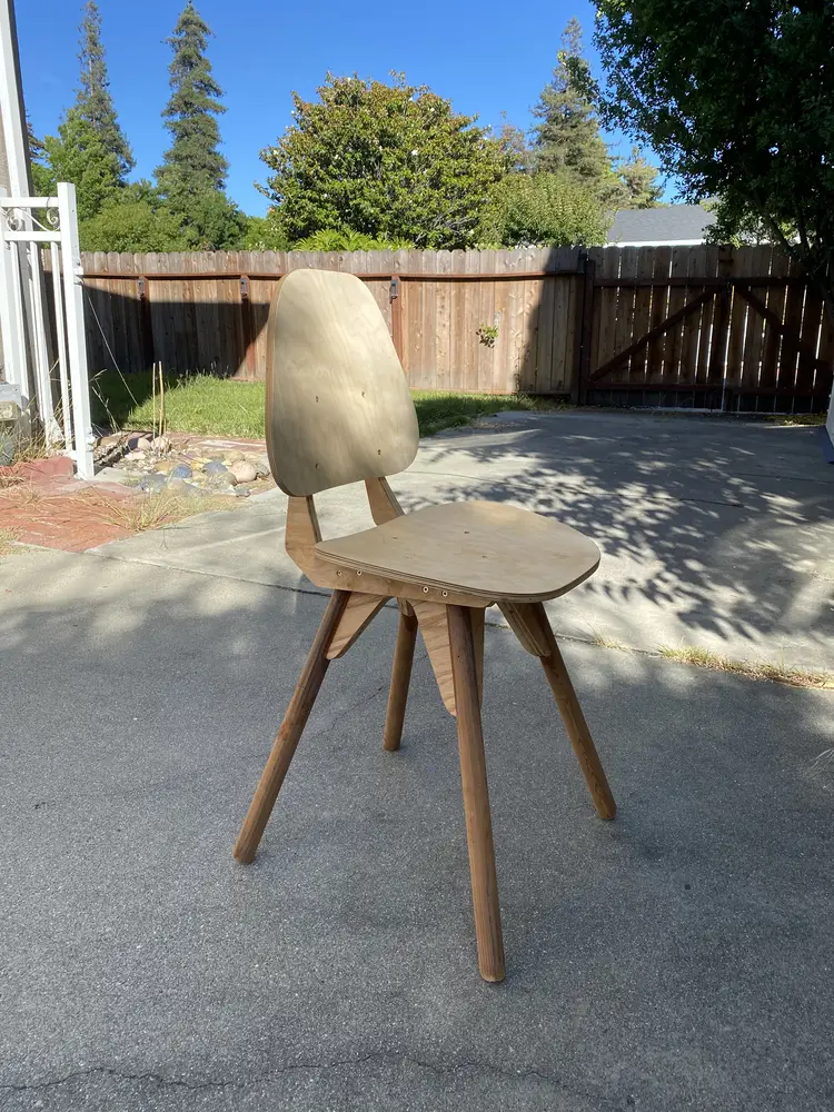 Plywood dining chair with a contoured back and seat on splayed dowel legs