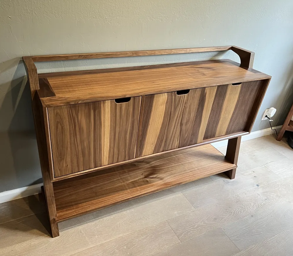 Mid-century black walnut sideboard with a cabinet door and two sliding doors, a gallery rail, and a lower shelf